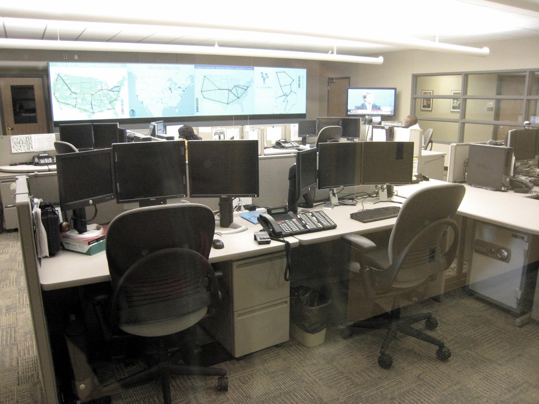 Centro de operações de rede. Imagem ilustrativa de um ambiente de monitoramento contínuo.
