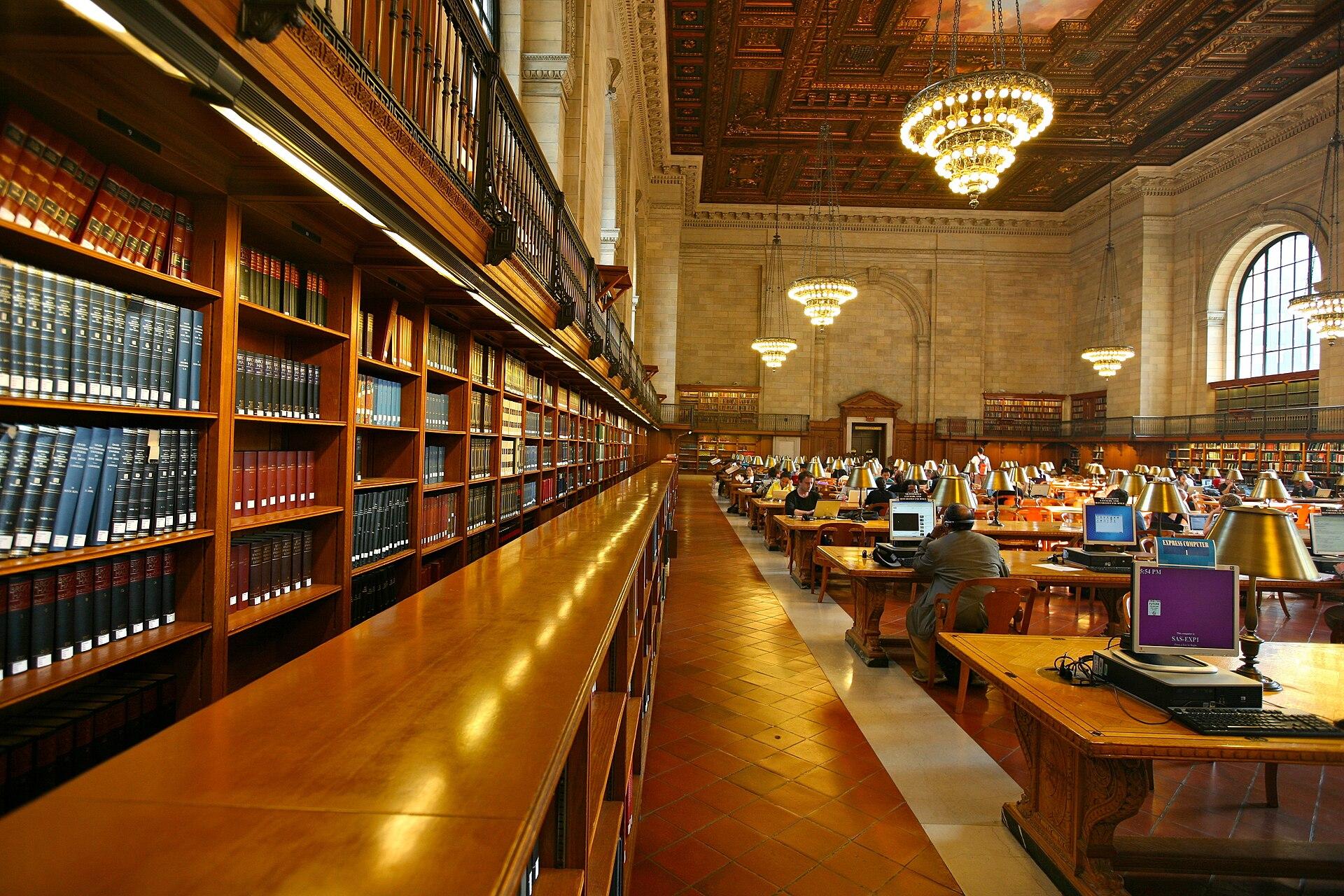 Estantes de livros e computadores em uma biblioteca. Imagem ilustrativa da disputa sobre uso de obras protegidas em treino de modelos.