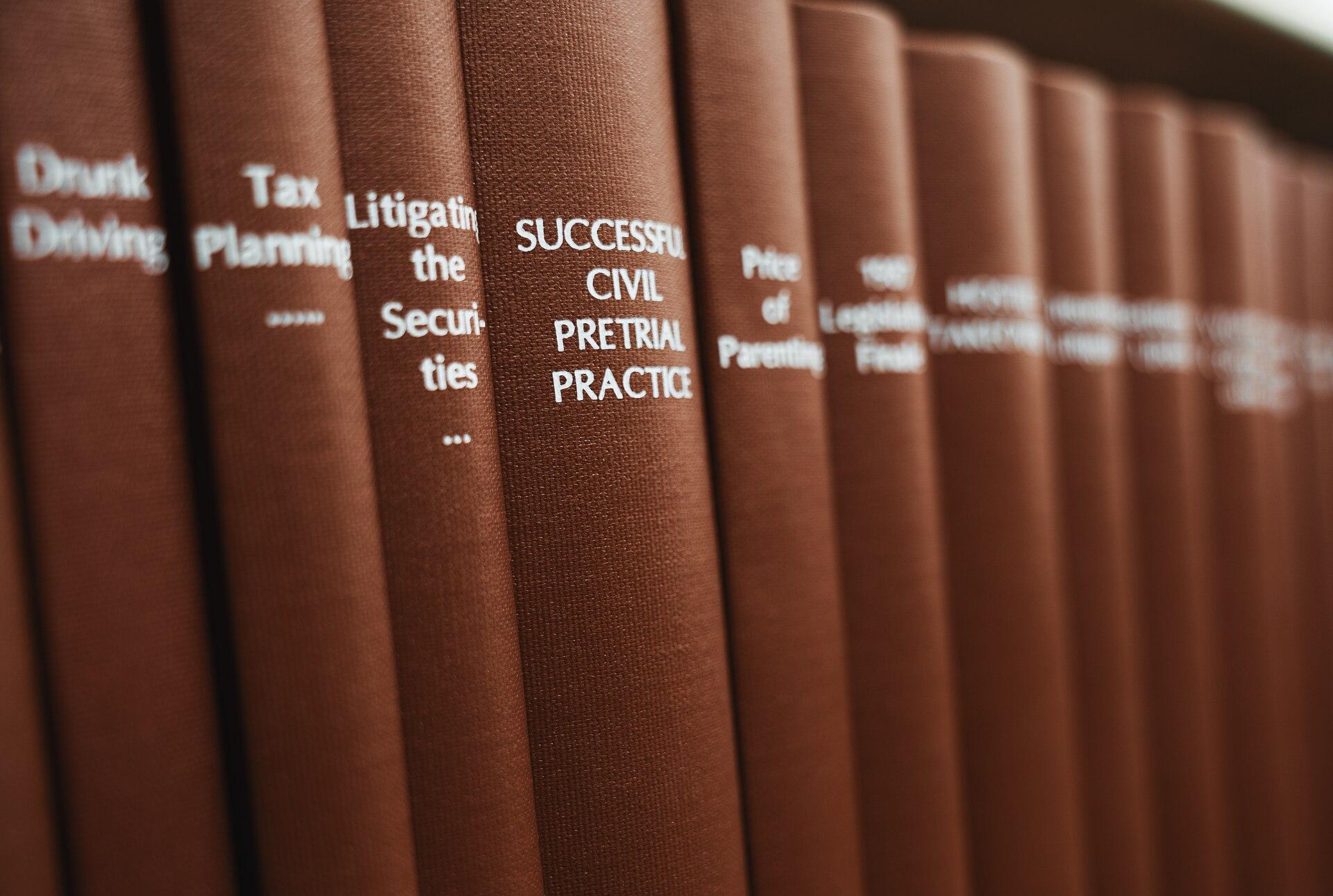 Livros de prática processual em uma biblioteca de direito. Imagem ilustrativa do trabalho que o pacote do Google promete automatizar.