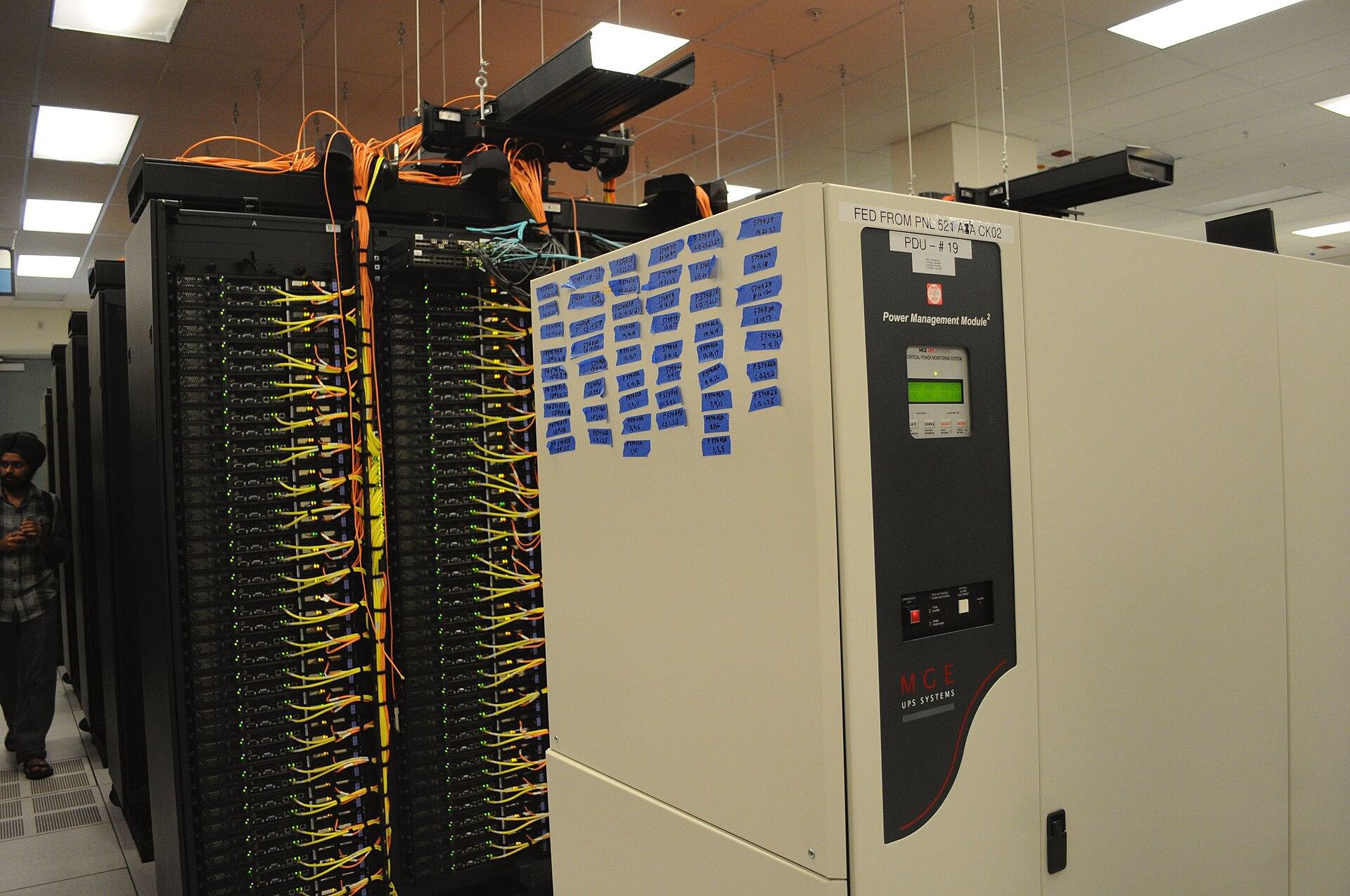 Racks e cabeamento de rede no data center do NERSC, nos Estados Unidos. Imagem ilustrativa: os agentes descritos na matéria rodavam em ambiente interno da OpenAI, que não aparece na foto.