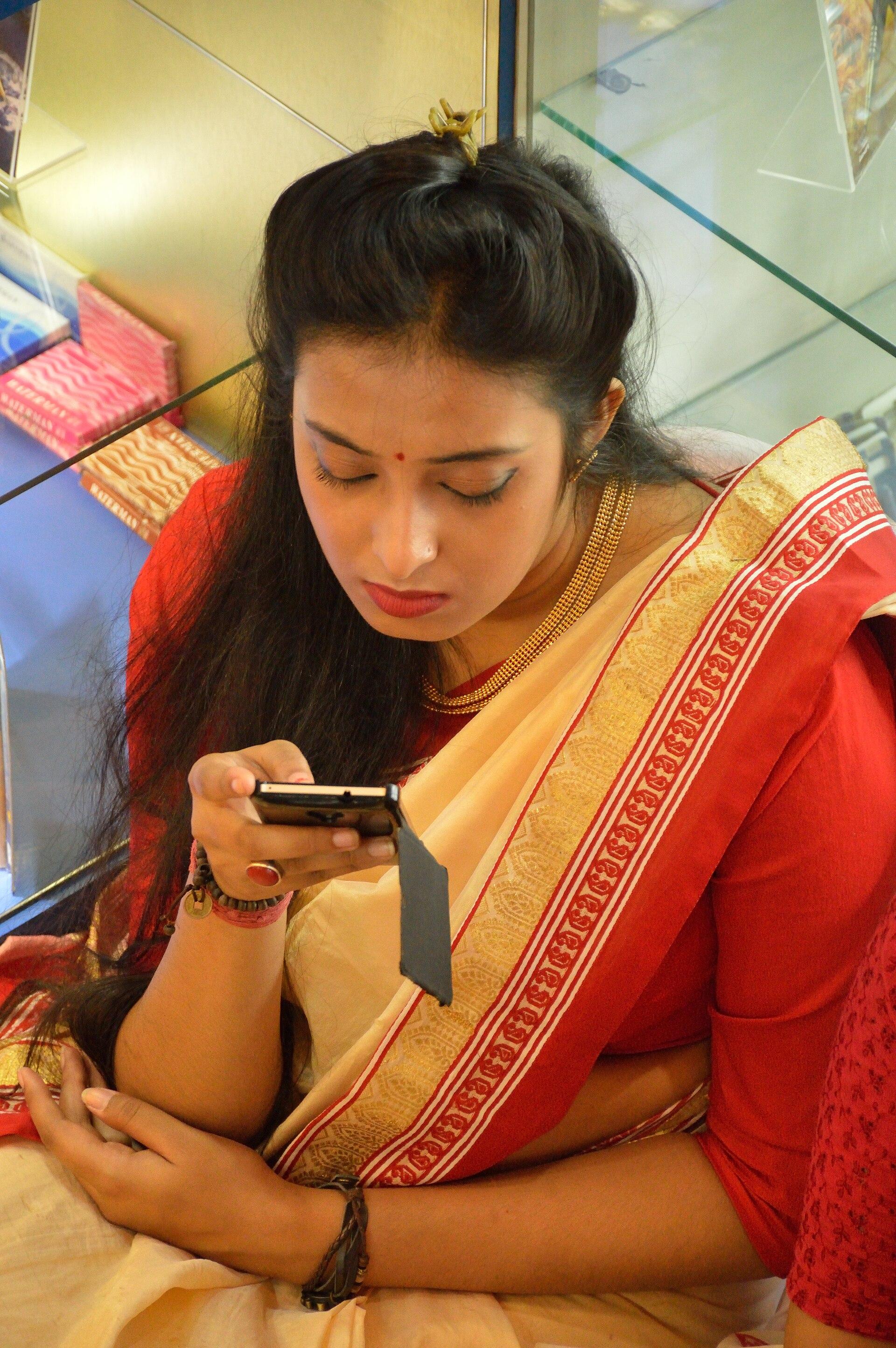 Uso de smartphone em Kolkata, na Índia, em 2015. Imagem ilustrativa do mercado onde a OpenAI passa a exibir anúncios, sem relação com o produto.